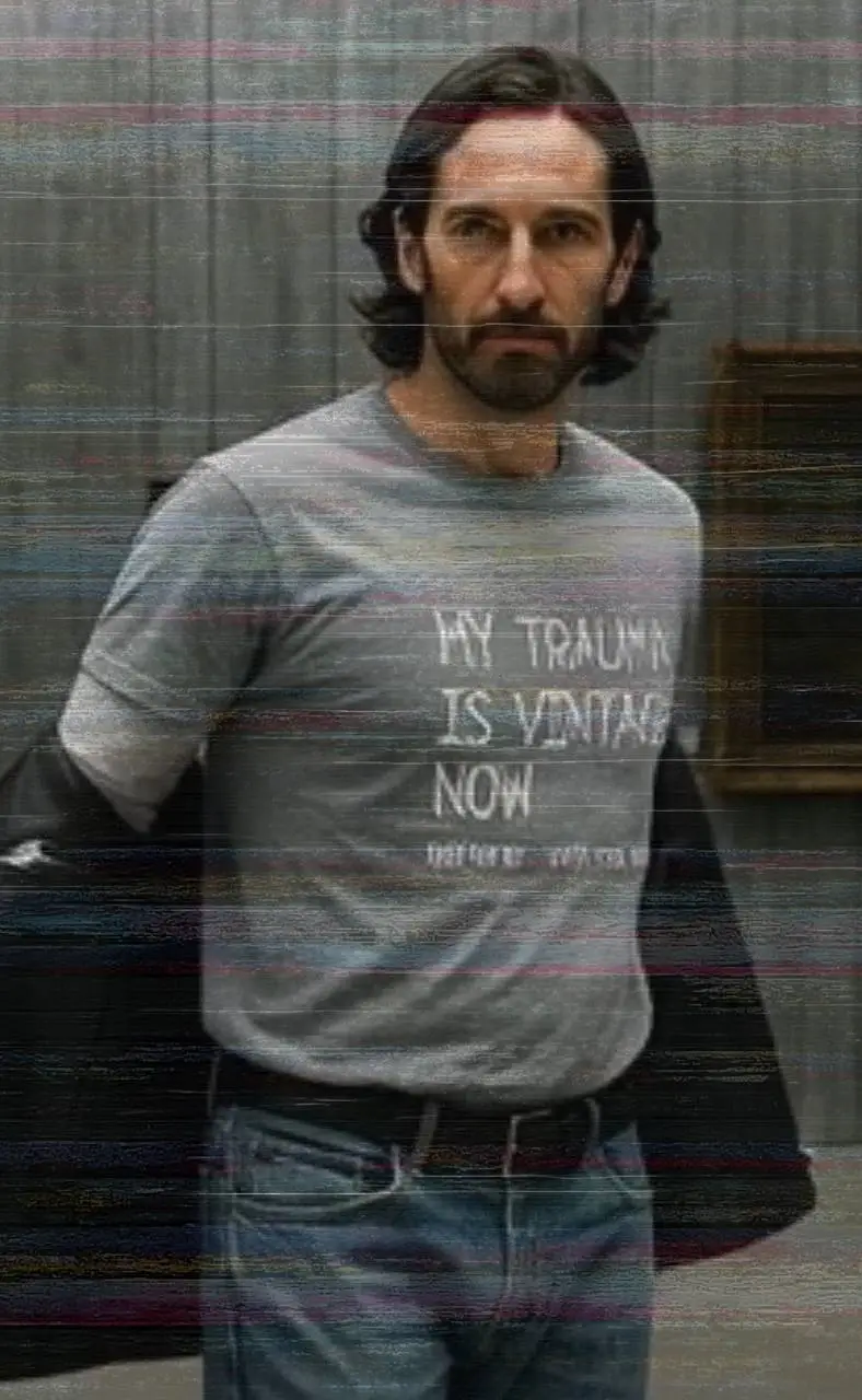 Man wearing a grey t-shirt reading My Trauma Is Vintage Now, shot with glitch-like distortion.